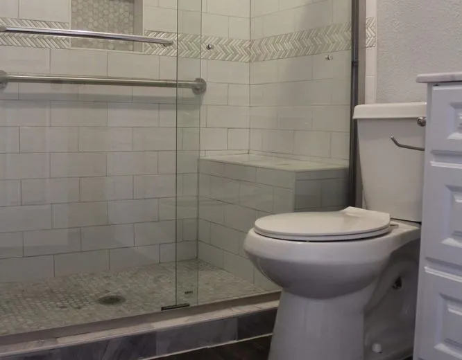 Completed bathroom remodel with glass shower enclosure, new vanity, and flooring