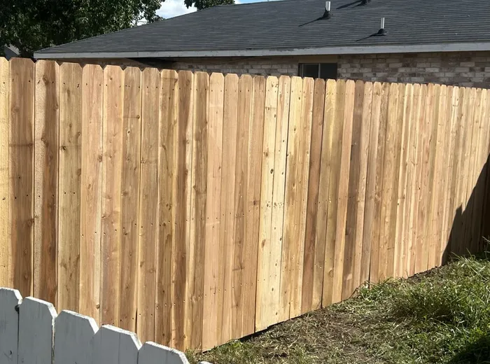Newly installed cedar wood privacy fence along a backyard