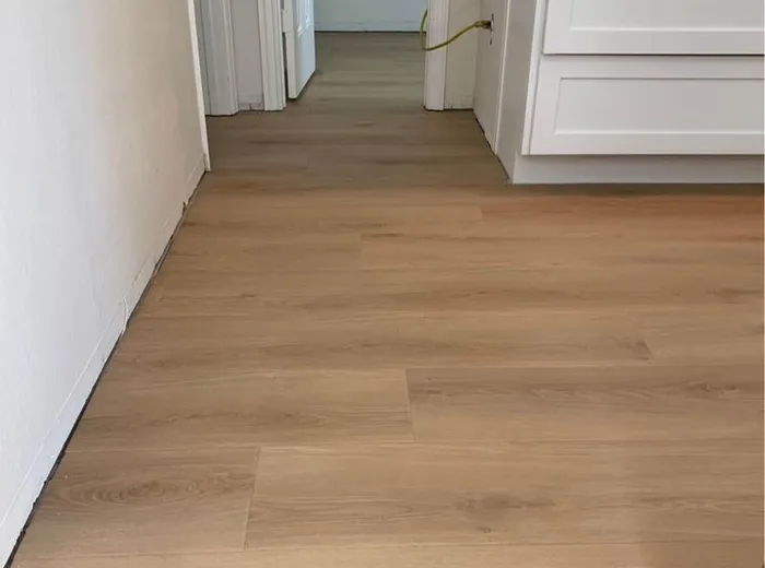 Newly installed wood-look flooring in a hallway leading to a walk-in closet