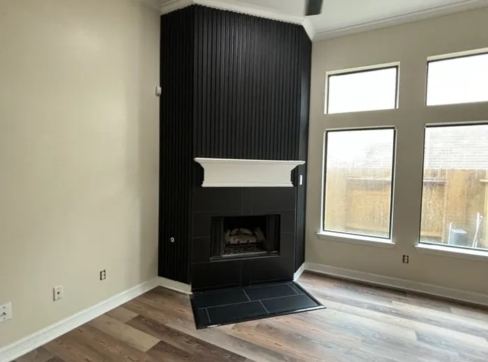 Finished living room remodel with a black shiplap fireplace accent wall and new flooring